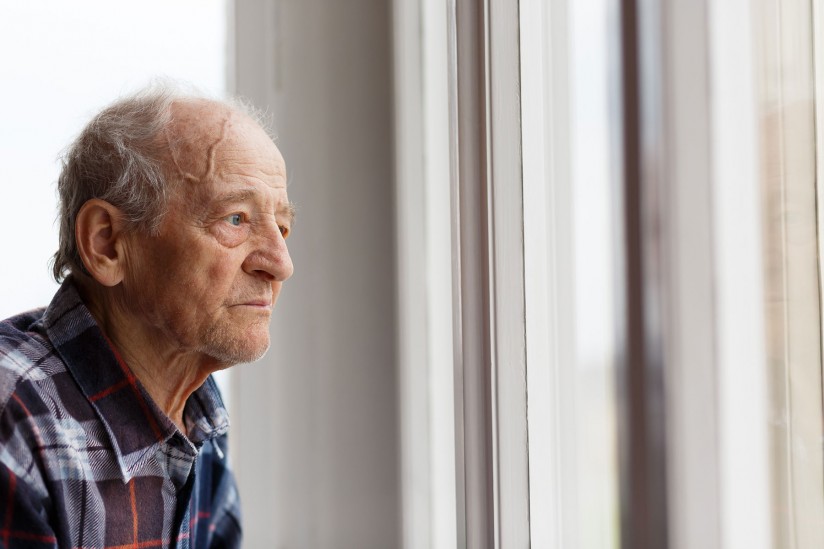 man looking out window