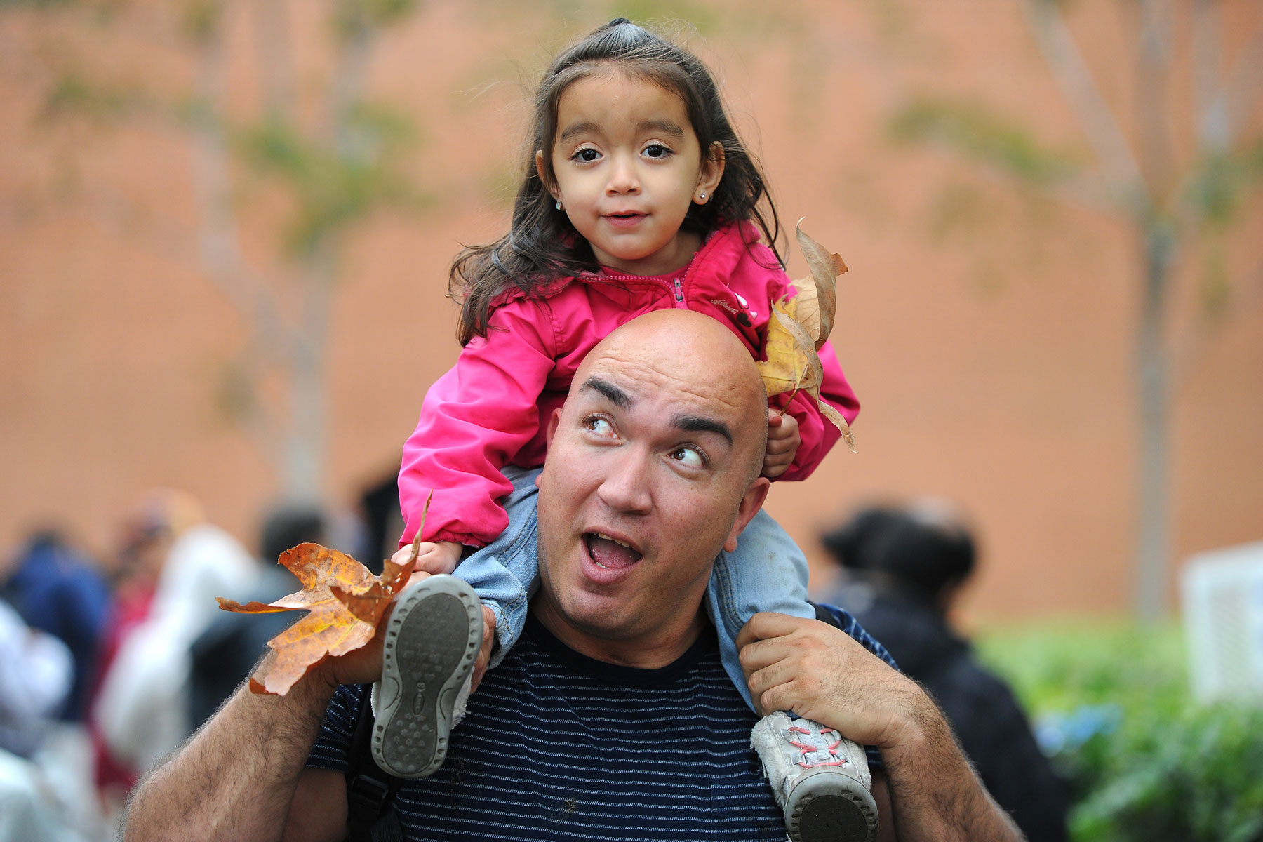 Dad carrying daughter on shoulders