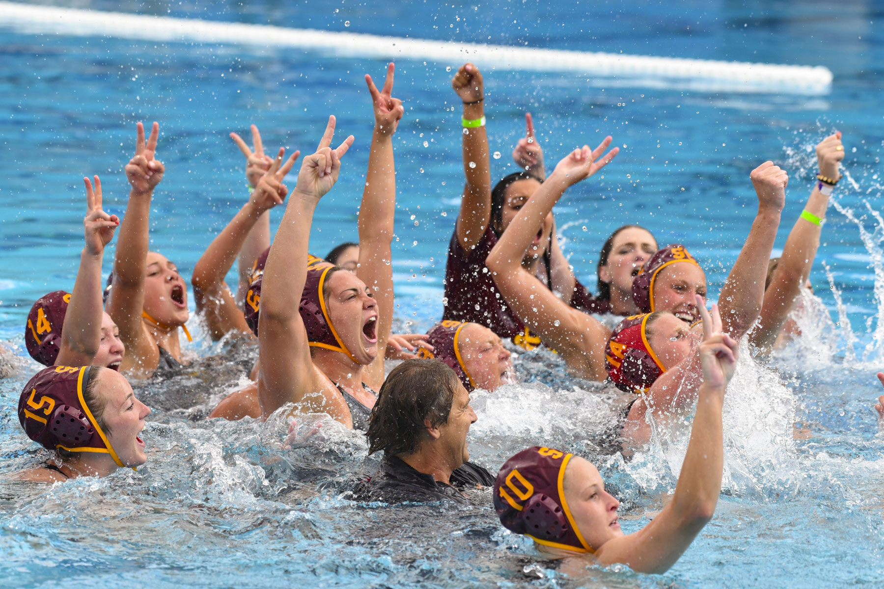 Water Polo team celebrating in pool.