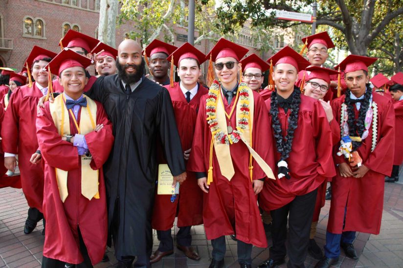 Group of graduates celebrates with teacher