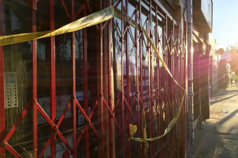 gate closed across storefront with caution tape