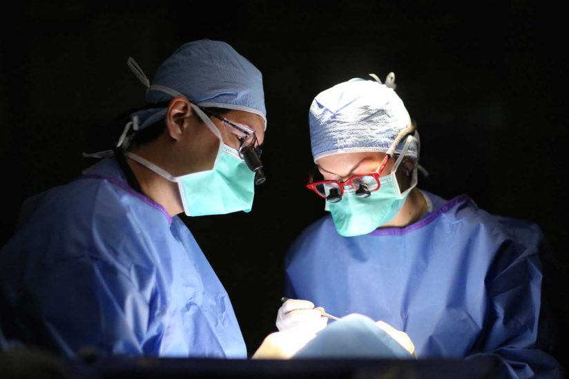 doctors Jonathan Kim and Jesse Berry working with eye patient