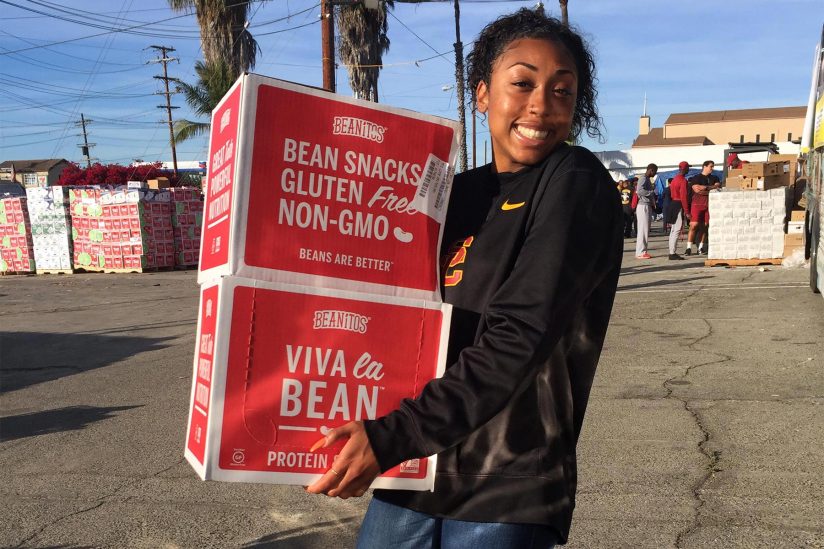Student-athlete Mecca McGlaston helps organize boxes of food.
