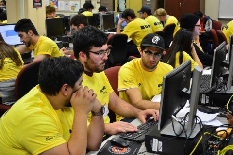 Teams in front of computers working together